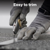 A close-up of gloved hands using a utility knife to trim a rubber gym floor, with the text 'Easy to trim' overlaid at the top.